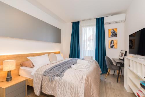 a bedroom with a bed and a desk and a television at LuxArt City Spa Gallery Residence Krk in Krk