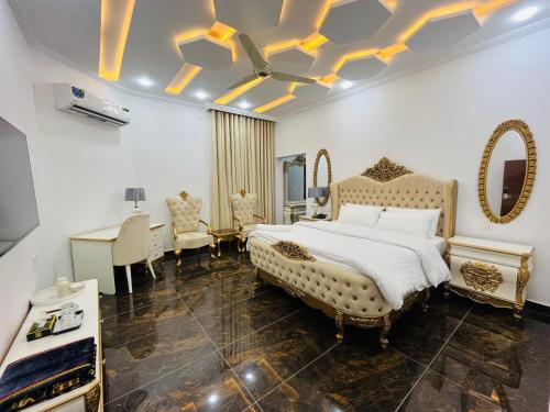 a bedroom with a large bed and a desk at Best Eastern Hotel Multan in Multan