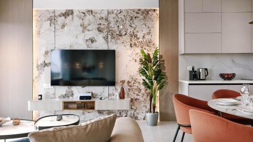 ein Wohnzimmer mit einem Fernseher an der Wand in der Unterkunft Mira Mare Luxury Villa by Aktis Villas in Nea Skioni