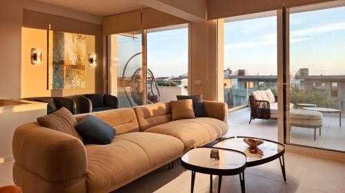 ein Wohnzimmer mit Sofa und Tisch in der Unterkunft Mira Mare Luxury Villa by Aktis Villas in Nea Skioni