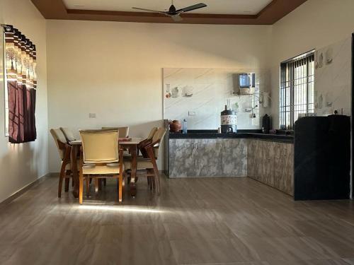 Una cocina con una mesa y sillas en una habitación. en Neelkanth Villa, en Ahmedabad