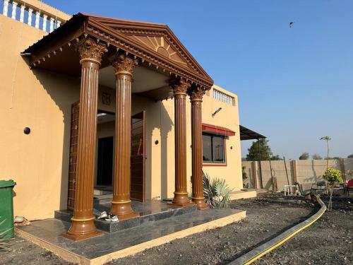 un edificio con columnas en la parte delantera en Neelkanth Villa, en Ahmedabad