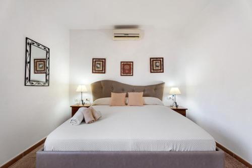 a bedroom with a large white bed with two lamps at Bonita Casa Arianny con Piscina in Arona