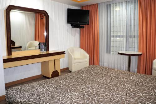 een hotelkamer met een bed en een spiegel bij Hotel Condado in Mexico-Stad