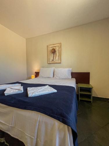 a bedroom with a bed with two towels on it at Pousada Céu de Estrelas in Bonito