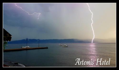 a lightning bolt in the sky over a body of water at Artemis Hotel in Amarinthos