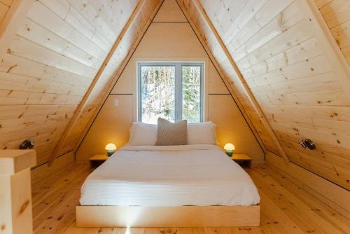 a bedroom with a bed in a small room at Canadian Classic - Spa - Sauna - Fire - Forest in Val-David
