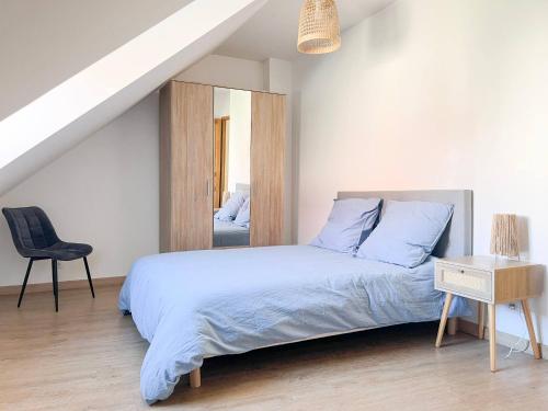 ein Schlafzimmer mit einem Bett, einem Stuhl und einem Spiegel in der Unterkunft Maison 6 personnes - Etaples in Étaples