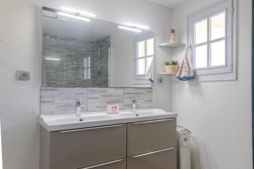 a white bathroom with a sink and a mirror at Le Logis Chez Bompain in Brizambourg