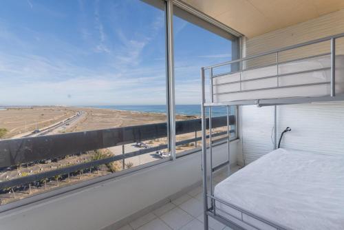 サン・シプリアンにあるAppartement vue sur merのビーチの景色を望むベッドルーム1室(ベッド1台付)が備わります。