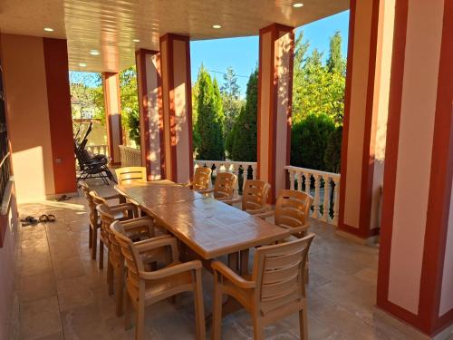 a large dining room with a wooden table and chairs at Quba Village Villa in Quba