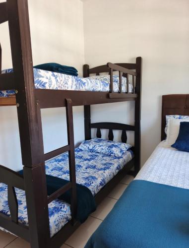 a room with two bunk beds and a bed at Residencial DO MAR in Bombinhas