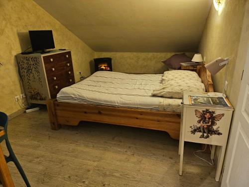 una camera da letto con un letto e una cassettiera con un camino di Les lutins a Saffloz