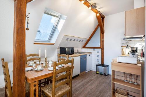 a kitchen and dining room with a wooden table and chairs at Haus Übersee Wohnung Sansibar in Travemünde