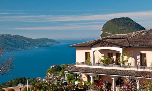 a building on a hill with a view of the water at Hotel Garni Bel Sito in Tremosine Sul Garda