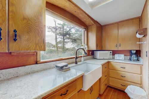a kitchen with a sink and a window at McKinnon's Beach House in Rockaway Beach