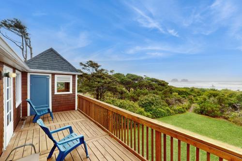 a deck with two chairs and a view of the ocean at McKinnon's Beach House in Rockaway Beach
