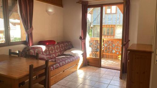 una sala de estar con un sofá y una mesa en Chalet de l'Ardoisière, en Saint-Colomban-des-Villards