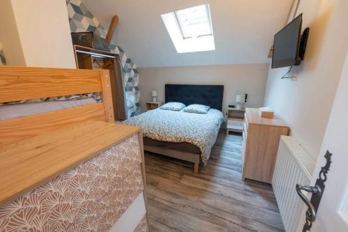 a bedroom with a bed and a television in it at Loft in Brizambourg
