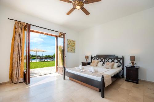 une chambre avec un lit et un ventilateur de plafond dans l'établissement Casa Fortuna, à Manacor