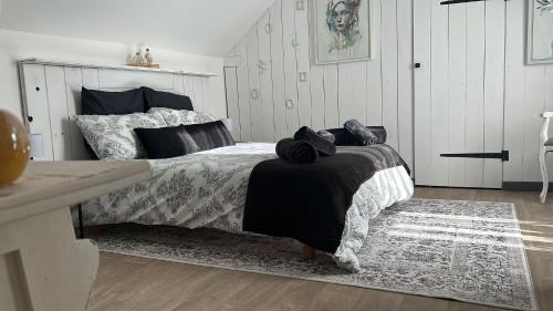 a bedroom with a bed with a black and white comforter at Beautiful 2-Bedroom Gîte in Montenay in Montenay