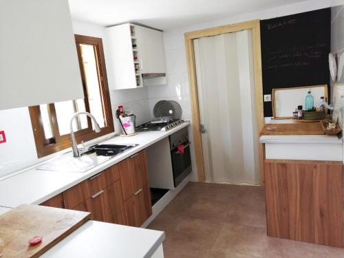 une cuisine avec des comptoirs blancs et un tableau noir au mur dans l'établissement Son Aloui Mallorca, à Llubí