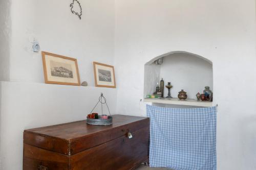 a room with a wooden dresser and an arched niche at Traditional Hora House Serifos in Serifos Chora
