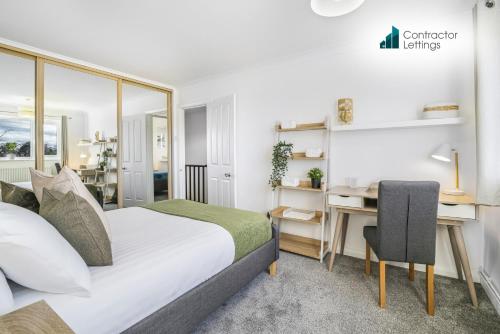 una habitación de hotel con una cama y un escritorio en 4 Bedroom Elegant House Near Peterborough City Center with Free Parking - Angus Suites by Contractor Lettings, en Peterborough