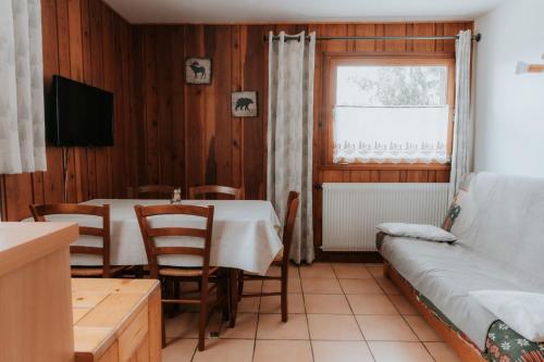 ein Wohnzimmer mit Tisch und Couch in der Unterkunft Jean Pierre Skilodge in La Toussuire