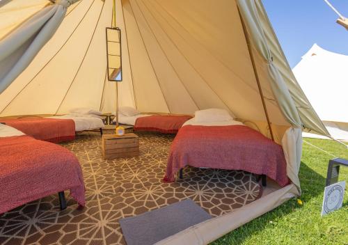 a tent with two beds and a ladder in it at Nine Yards Bell Tents - Lytham in Lytham St Annes