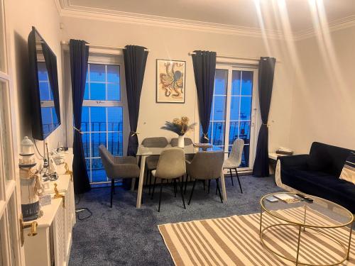 a living room with a table and chairs at Seaside Escape in Thorpe Bay