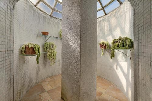 een badkamer met planten op planken en een raam bij Secluded House - Quinta La Rabide in Portinho da Arrábida