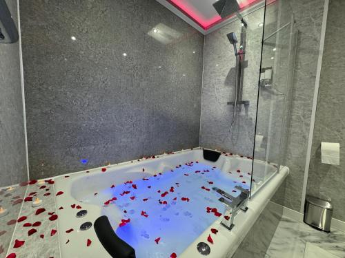 a bathroom with a tub with red flowers in it at Suite 1 Private Jacuzzi Spa Hot Tub & Sauna in Attercliffe