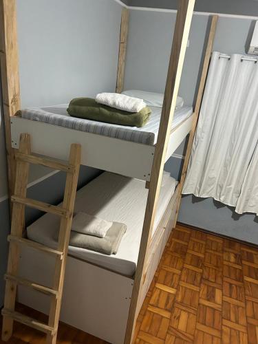 a couple of bunk beds in a room with a ladder at Flórida in São Carlos