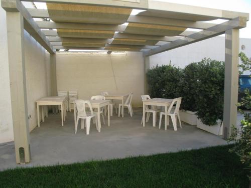 a patio with tables and chairs under a pergola at La Casa Dei Nonni in Custonaci
