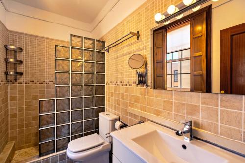 un bagno con un water, un lavandino e uno specchio di Casa Vacacional Golfin ad Arona