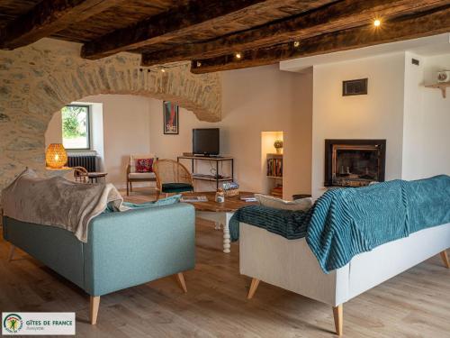 a living room with two couches and a fireplace at Gite Les Albarets in Rieupeyroux