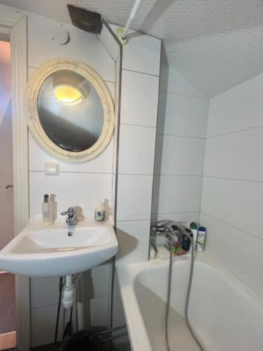 a bathroom with a sink and a mirror and a tub at Ugglegatan 17 - Två rum & kök in Linköping