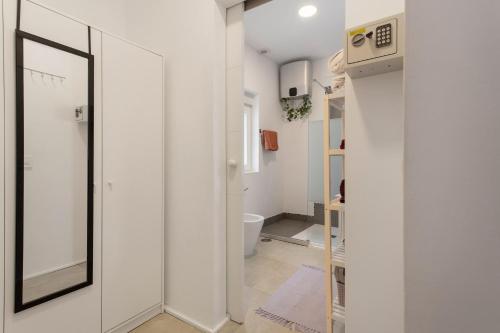 a white bathroom with a toilet and a mirror at Terrassenzeit 3 in Puerto de la Cruz