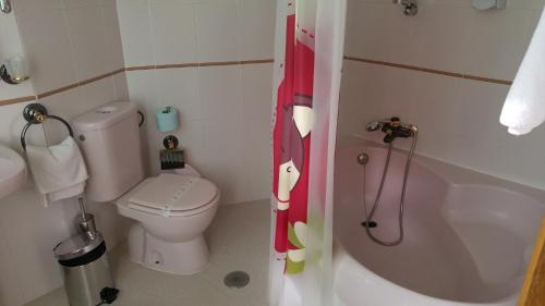 a small bathroom with a toilet and a bath tub at Hotel Cabañas in Puertollano
