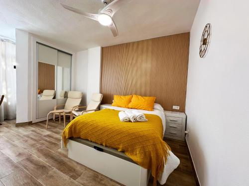 sypialnia z łóżkiem z żółtym kocem w obiekcie Centro Torremolinos w mieście Torremolinos
