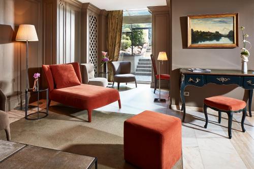 a living room with orange chairs and a desk at Hôtel Régent Contades in Strasbourg