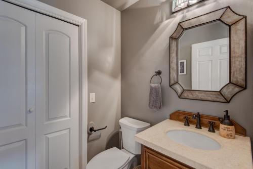 a bathroom with a toilet and a sink and a mirror at The Wander Inn in Blowing Rock