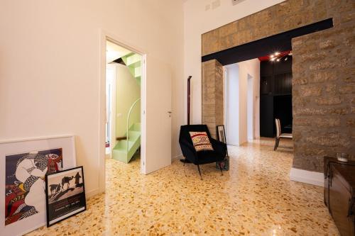 a living room with a chair and a stone wall at Maison Noir Napoli in Naples