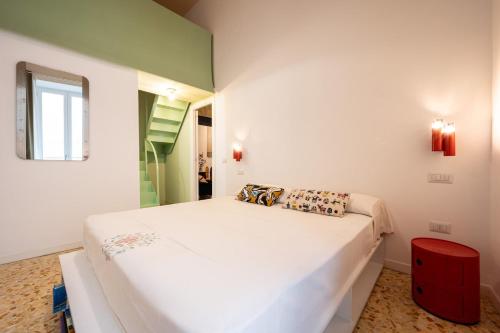 a bedroom with a white bed and a red stool at Maison Noir Napoli in Naples