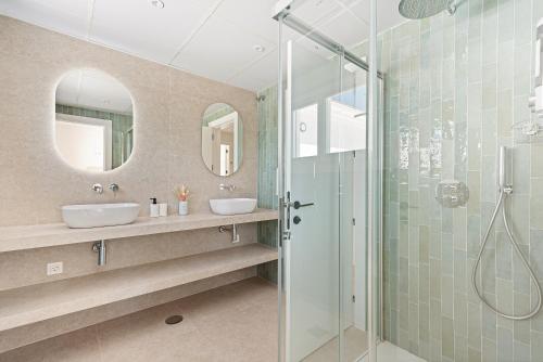 a bathroom with two sinks and a glass shower at Villa Clery Algarrobo in Algarrobo