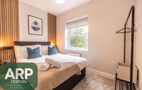 a bedroom with a bed and a window at Green Park House, Private Garage and Parking in Coventry