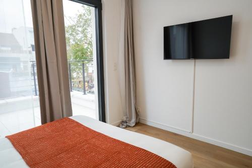 - une chambre avec une télévision murale à côté d'une fenêtre dans l'établissement Appartment Veeweyde 5, à Bruxelles