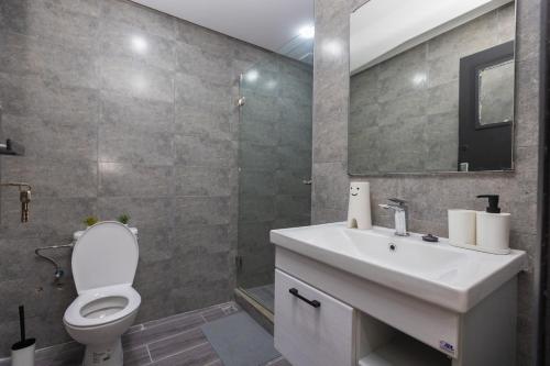 a bathroom with a toilet and a sink and a mirror at Élégant 2BR au cœur de Hassan by MERAT HOME in Rabat