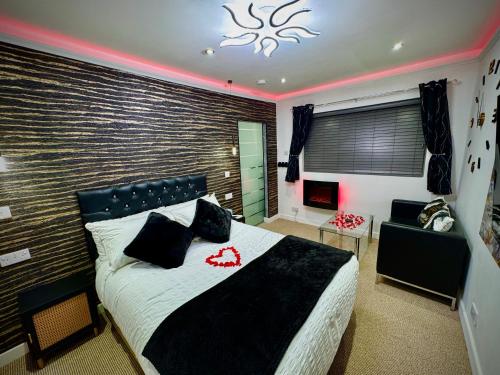 a bedroom with a large bed and a chair at Suite 1 Private Jacuzzi Spa Hot Tub & Sauna in Attercliffe